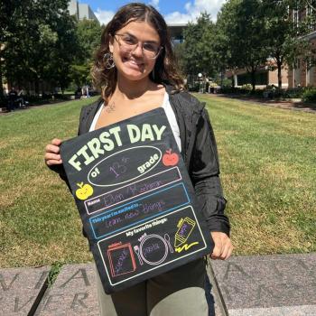 Female science student holding a first day of school board.