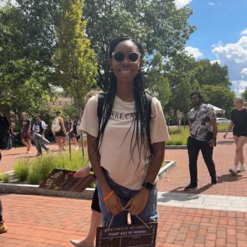Student holding a first day of school board.