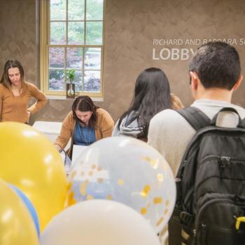 A line of students waiting to sign paper stars of the proudest accomplishment during the last year.