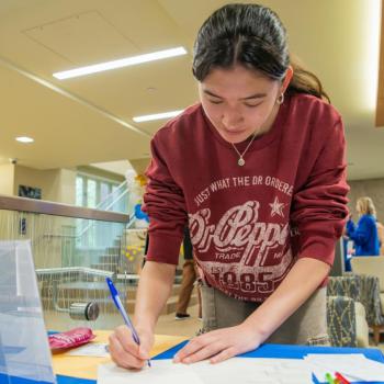 A coed writing a note about her college experience.