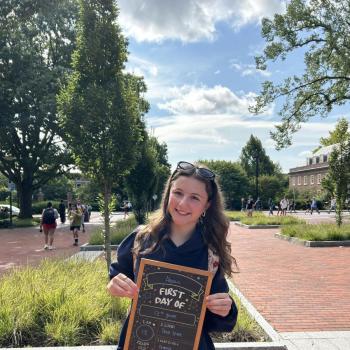 Student holding a first day of school chalkboard.
