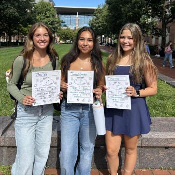 Three girls holding first day of school paper signs.