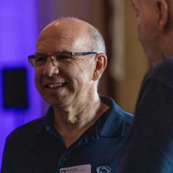 Close up of Robert Swift at the Franklin Institute talking with others