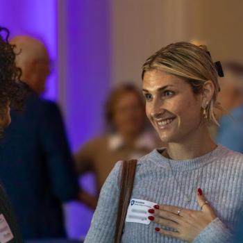 Meredith Cavanaugh speaking to someone else and smiling at the Franklin Institute 