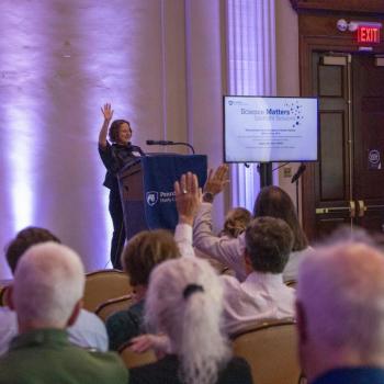 Tracy Langkilde, dean of the Eberly College of Science, raising her hand with audience members also raising their hands