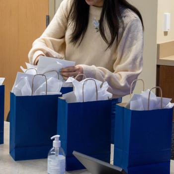 A coed student opens the gift bag that contains her college commencement stole.
