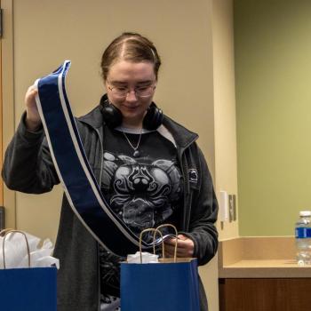 A coed looks at her college commencement stole after removing it from her gift bag.