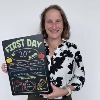 Dean Tracy Langkilde holding a first day of school chalkboard.